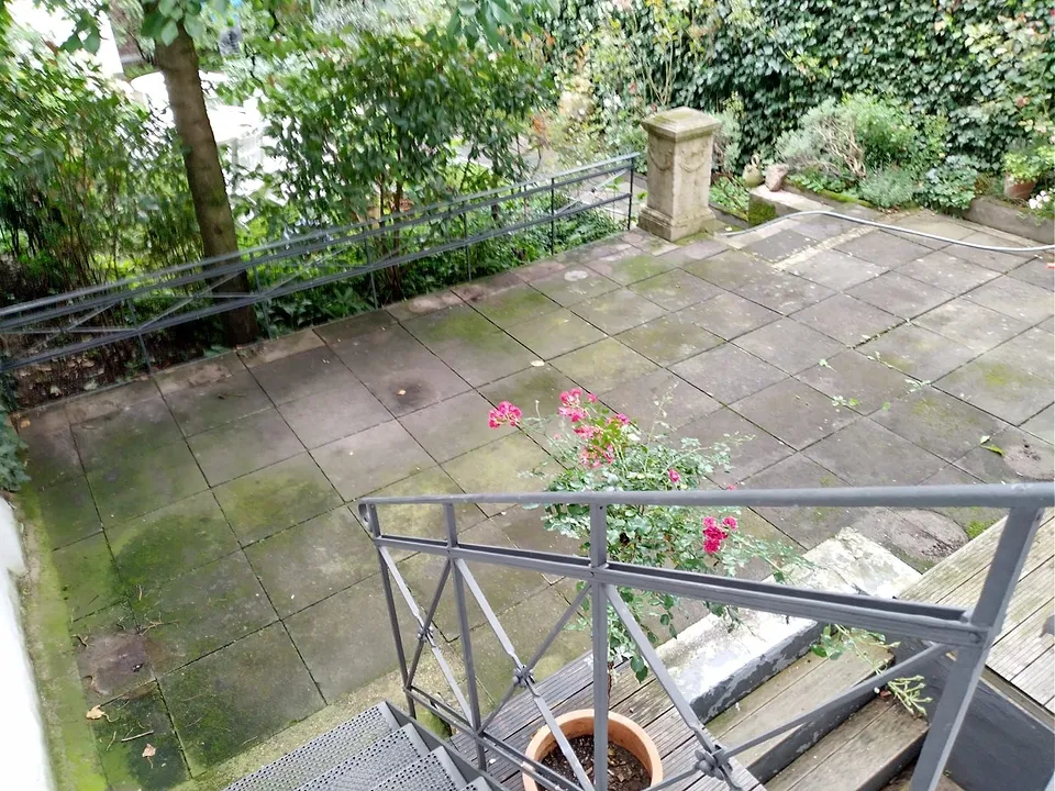 Dachterrasse mit grünem Belag vor der Behandlung.