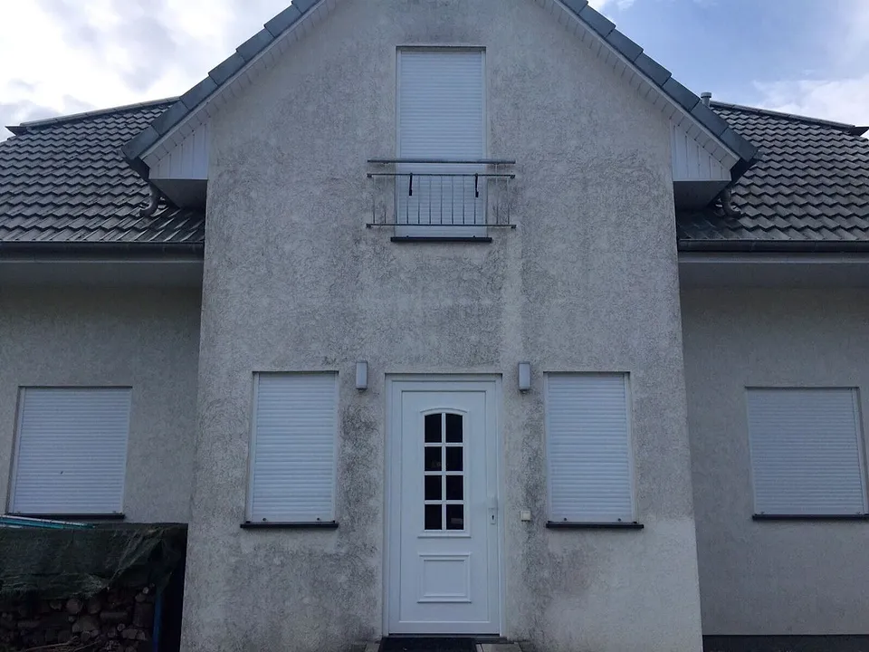 Vorher: Fassade mit Giebel, Algen und Grauschleier entfernt, ganz ohne Neuanstrich.